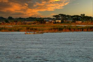 A serene boat ride during sunset on a calm river in Faridpur, Bangladesh.